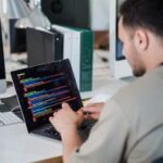 Software developer typing code on laptop