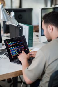 Software developer typing code on laptop