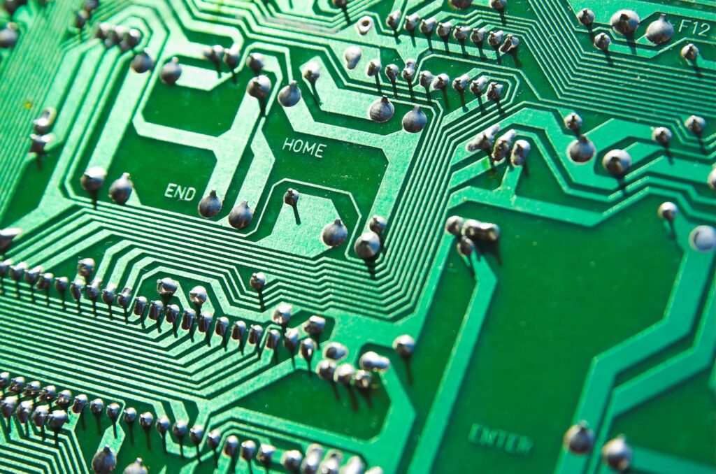 Green circuit board showing microchips and pathways for AI automation