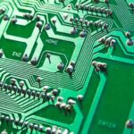 Green circuit board showing microchips and pathways for AI automation