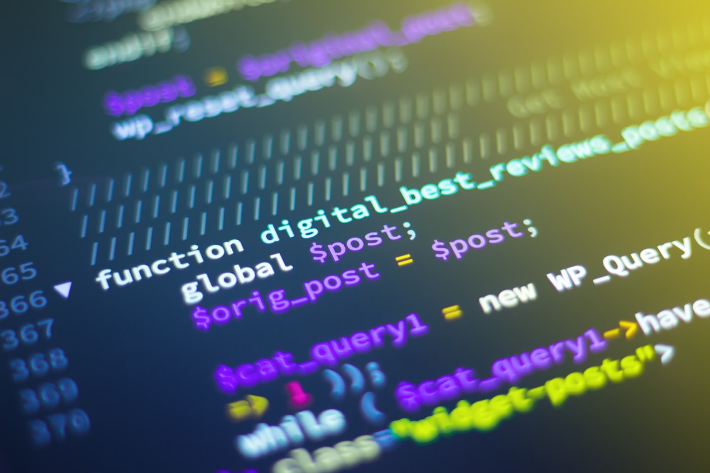 Developer coding on a laptop with multiple screens