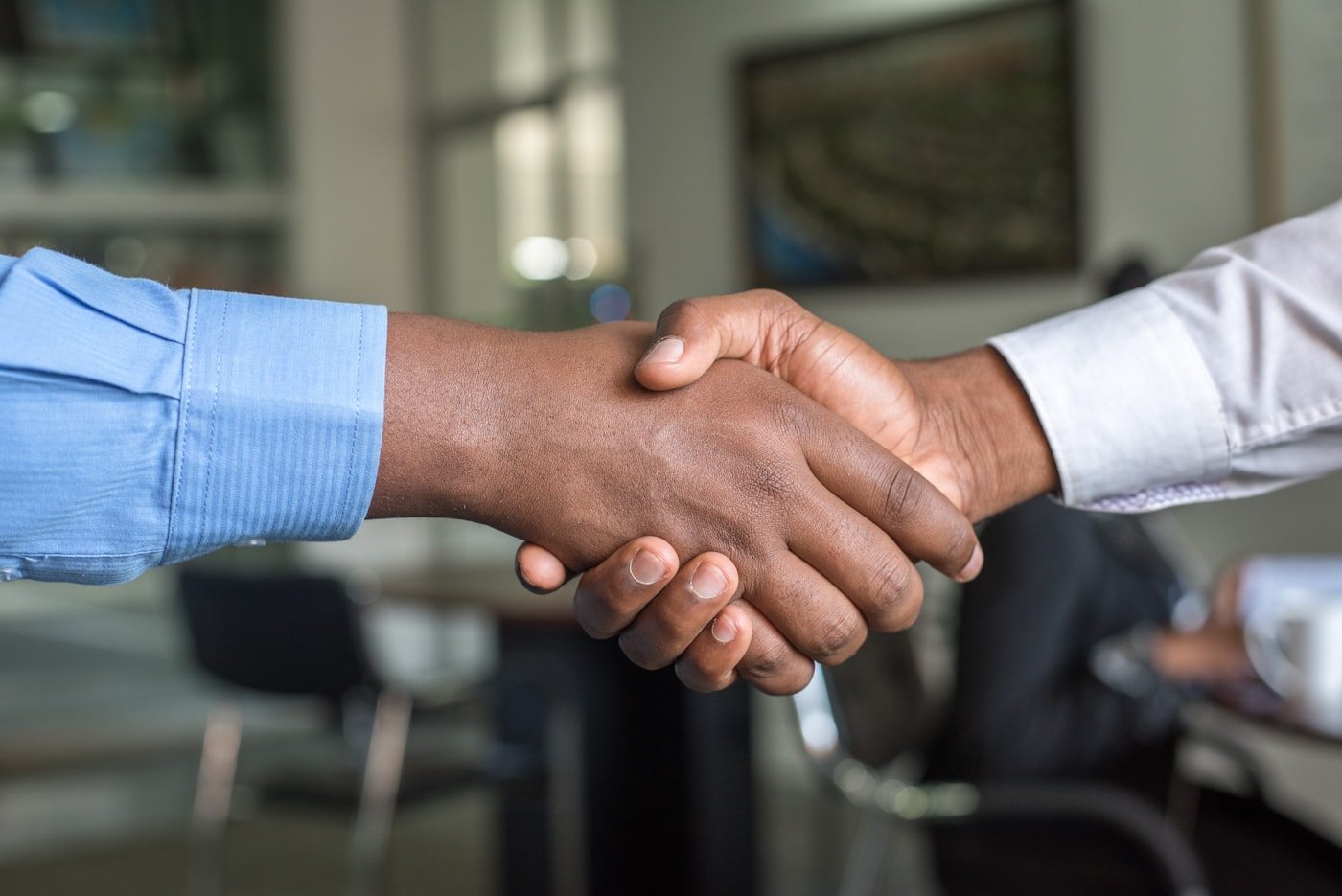 Business handshake over a wooden table